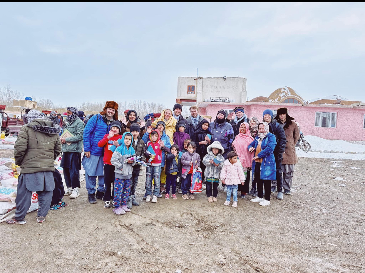 Travelers and local families during a winter visit in Bamyan