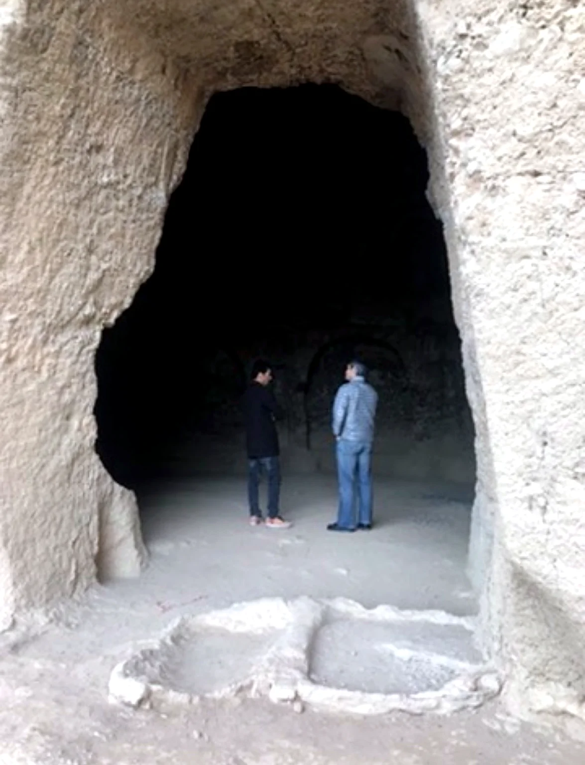Visitors inside a historic cave site in Bamyan